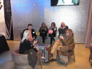 Teacher Open House 2015 participants sit on chairs and couches in the Warhol lobby.