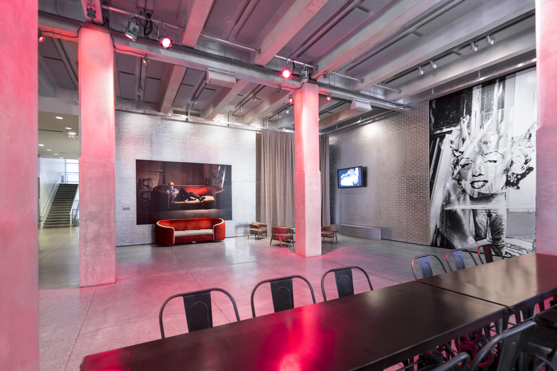 The entrance space at The Andy Warhol Museum with red lights lighting up the 4 pillars.